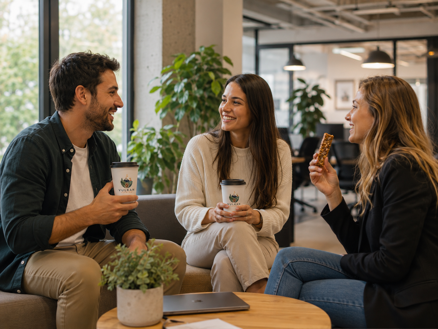 Tres personas disfrutando café y snack Vulkan en oficina